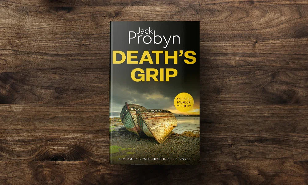 Book cover of Death’s Grip, an Essex Murder Mystery by Jack Probyn. A gritty crime thriller featuring two decaying, rusted boat hulls abandoned on a rocky shoreline at sunset. Book 2 in the DS Tomek Bowen series, perfect for fans of JD Kirk and JM Dalgliesh