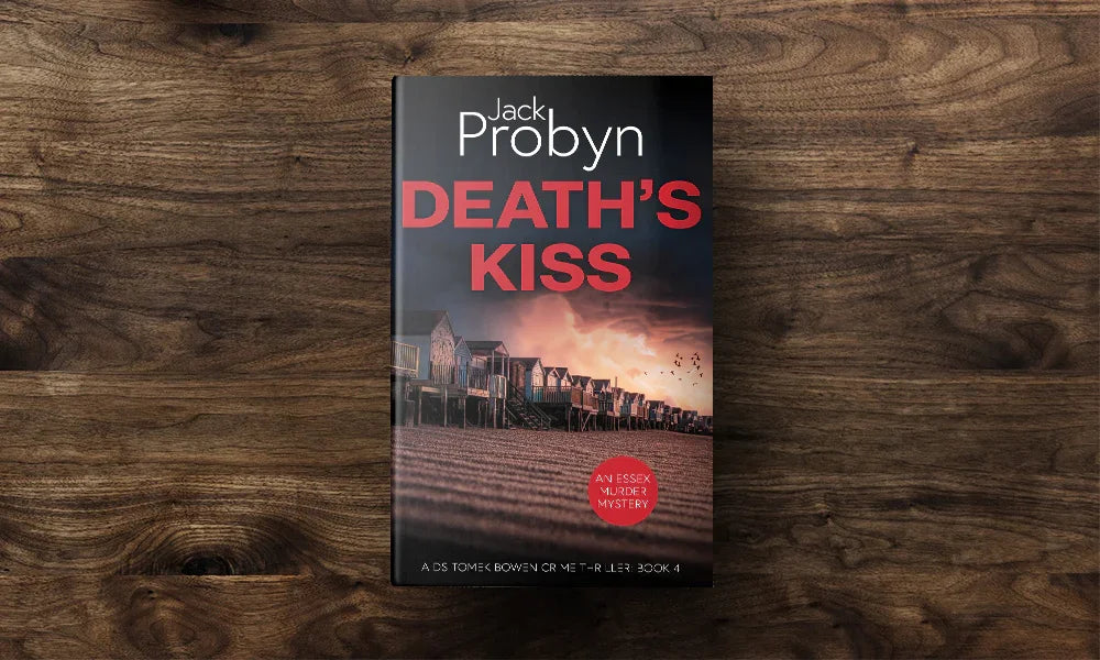 Book cover of Death’s Kiss by Jack Probyn. A gritty Essex Murder Mystery showing a long row of traditional beach huts on a shingle shore at dusk, with birds flying over a pink-hued sky. Book 4 in the DS Tomek Bowen series, perfect for fans of JD Kirk and JM Dalgliesh