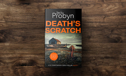 Book cover of Death’s Scratch by Jack Probyn. A gritty Essex Murder Mystery featuring an old stone boathouse and a rotting wooden ship on a marshy shoreline, with a rusted Celtic cross in the foreground. Book 9 in the DS Tomek Bowen series, perfect for fans of JD Kirk and JM Dalgliesh